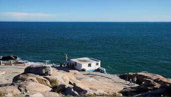People stand near a building overlooking the Taiwan Strait, at the 68-nautical-mile scenic spot, one of mainland China's closest points to the island of Taiwan, in Pingtan island, Fujian province, China. File image/ Reuters