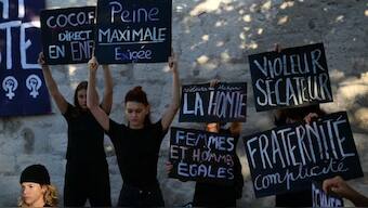 Demonstrators hold placards during a protest outside the courthouse during the trial of a man accused of drugging his wife for nearly ten years and inviting strangers to rape her at their home in Mazan, a small town in the south of France, in Avignon. AFP