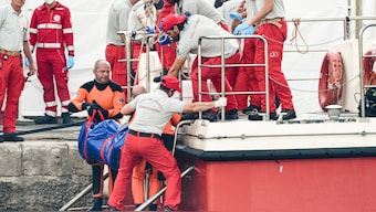 Italian firefighter divers bring ashore in a plastic bag the body of one of the victims of a shipwreck, in Porticello, Sicily, southern Italy, Thursday, August 22, 2024. AP