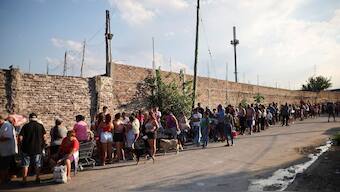 People wait in line to receive a charity food bag, outside the NGO Sal de la tierra, in Villa Fiorito, a working-class neighborhood on the outskirts of Buenos Aires, Argentina, February 27, 2024. File Image/Reuters