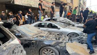 People gather at the scene of an Israeli missile strike in the southern suburbs of Beirut, on Friday. AP