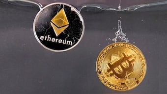Tokens representing cryptocurrencies bitcoin and ether plunge into water in this illustration taken May 17, 2022. File Image/Reuters