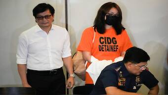 Philippine Secretary of Interior and Local Government Benhur Abalos, left, stands beside dismissed Bamban town Mayor Alice Guo, rear right, during a press conference after Guo arrived at a private hangar in the City of Pasay, Philippines, early Friday, Sept. 6, 2024, following her deportation from Indonesia. AP