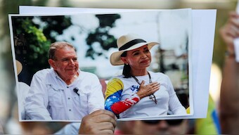 A person holds a picture of Venezuelan opposition presidential candidate Edmundo Gonzalez and Venezuela's opposition leader Maria Corina Machado. Reuters
