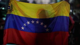 A woman holds a Venezuelan flag. File Photo- Reuters