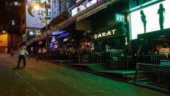 Bar staff members stand in the middle of the road to promote their bars and restaurants in Lan Kwai Fong, a popular nightlife destination, in the financial central district of Hong Kong, China. Reuters
