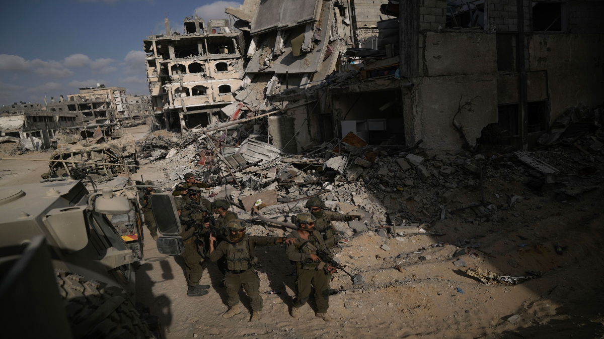 Israeli soldiers take up position next to buildings destroyed by the Israeli military in the Gaza Strip on Friday. AP Israeli soldiers take up position next to buildings destroyed by the Israeli military in the Gaza Strip on Friday. AP