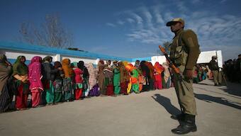 Voters line up to cast their votes as a security personnel stands guard outside a polling station during the last phase of Jammu and Kashmir Assembly election on December 20, 2014. Reuters File 