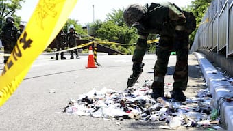 A South Korean soldier wearing protective gear checks trash from a balloon presumably sent by North Korea. File image/AP