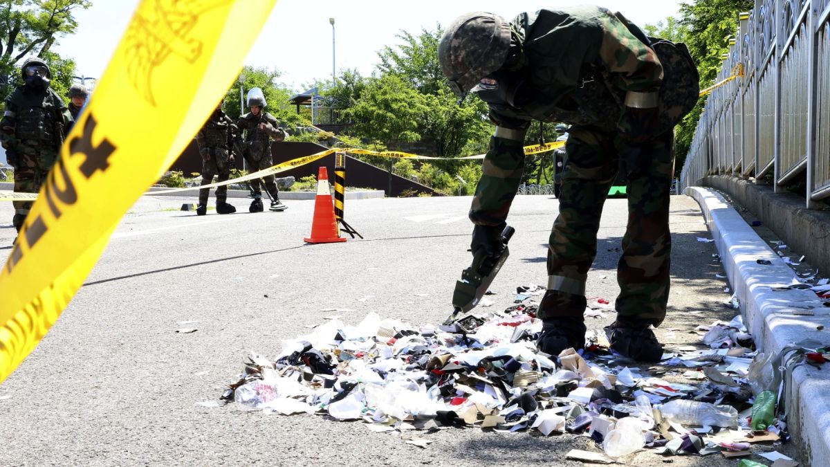 A South Korean soldier wearing protective gear checks trash from a balloon presumably sent by North Korea. File image/AP A South Korean soldier wearing protective gear checks trash from a balloon presumably sent by North Korea. File image/AP