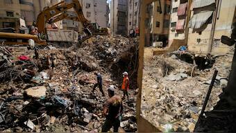 Emergency workers use excavators to clear the rubble at the site of Friday's Israeli strike in Beirut's southern suburbs, Lebanon. AP