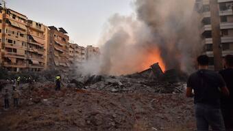 People watch as a blaze rages amid the smoldering rubble of a building destroyed in an Israeli airstrike targeting Hezbollah's main headquarters in Beirut's southern suburbs on September 27, 2024. Photo-AFP
