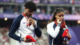 Simran Sharma kisses her bronze medal while her guide Abhay Singh looks on during the medal presentation ceremony for the women's 200m T12 event in the Paralympic Games in Paris. Reuters