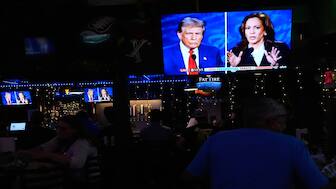 People watch a debate between Democratic presidential nominee Vice President Kamala Harris, right, and Republican presidential nominee former President Donald Trump, at Sports Grill Kendall, where the Miami-Dade Democratic Hispanic Caucus had organised a watch party, on Tuesday, in Miami. AP