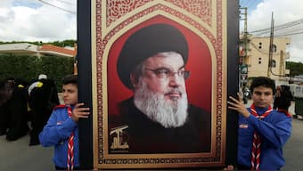 Boys scouts carry a picture of Hezbollah leader Sayyed Hassan Nasrallah during the funeral of Hezbollah member Ali Mohamed Chalbi in Kfar Melki, Lebanon, September 19, 2024. File Image/Reuters
