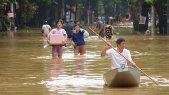 People carrying belongings wade in a flooded street in the aftermath of Typhoon Yagi, in Hanoi, Vietnam on September 12, 2024. AP