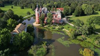 This aerial view shows the Bad Muskau palace in the landscape park in Bad Muskau, near Goerlitz in eastern Germany on August 22, 2024. In the gardens of Muskauer Park, which straddles the German-Polish border either side of the Neisse river, caretakers have mounted a fight back against the depredations caused by climate change. AFP