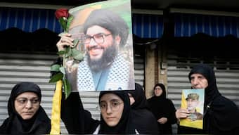 Hezbollah supporters carry pictures of Hezbollah commander Ibrahim Akil, right, and Hezbollah leader Hassan Nasrallah, centre, during Akil's funeral procession in Beirut's southern suburb. AP 