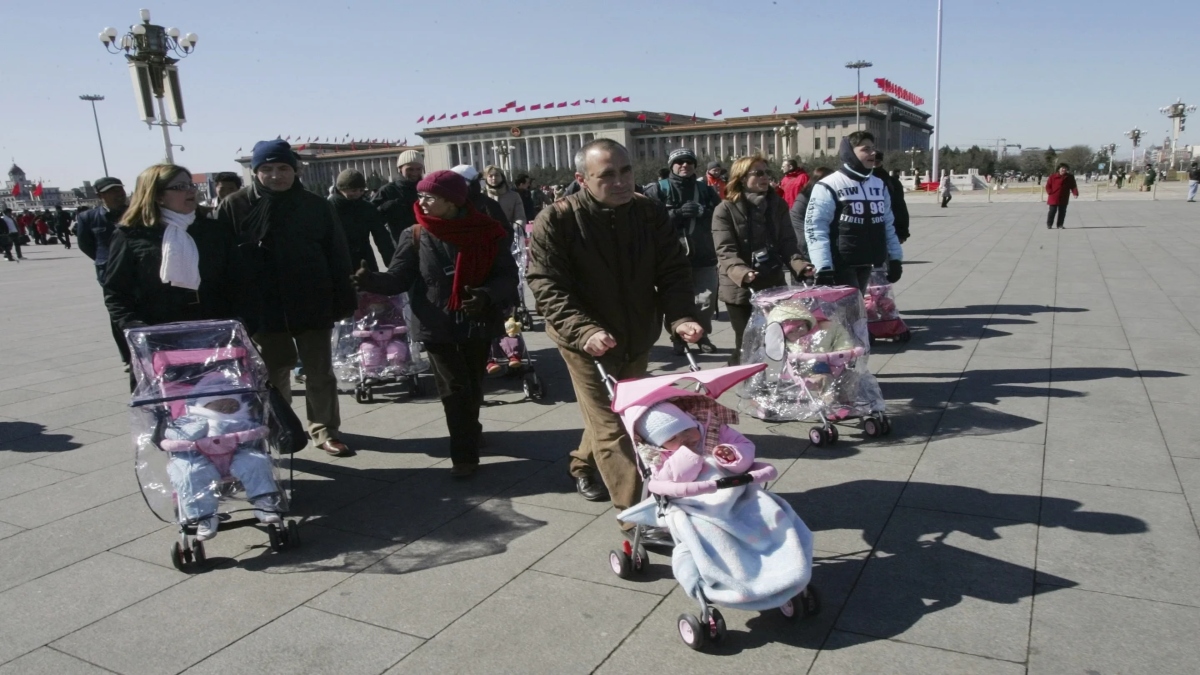 Spanish couples take their newly adopted Chinese children for a walk in Beijing’s Tiananmen Square, March 7, 2007. File Image: AP Spanish couples take their newly adopted Chinese children for a walk in Beijing’s Tiananmen Square, March 7, 2007. File Image: AP