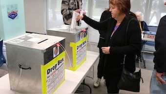 Arlene Bell puts her ballot into a drop box at the Silverado Ranch Community Center during the first day of early voting  in Las Vegas. AP