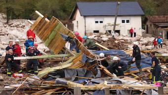 Rescuers search for missing people after floods and landslides in the village of Donja Jablanica, Bosnia. AP