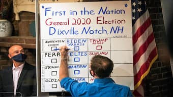A man tallies the votes from the five ballots cast just after midnight, Tuesday, Nov. 3, 2020, in Dixville Notch, NH. AP
