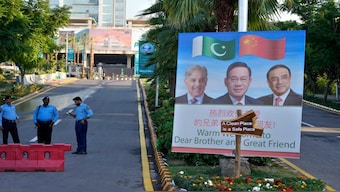 Police officers stand guard next to a welcoming billboard with portraits of China's Premier Li Qiang, center, Pakistan's Prime Minister Shehbaz Sharif and President Asif Ali Zardari, displayed at a road leading to the venue of the upcoming Shanghai Cooperation Organization (SCO) summit in Islamabad, Pakistan. AP