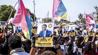 A poster of independent candidate Venacio Mondalane is held at an election rally in Maputo. AP