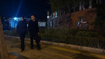 Plainclothes police officers pass by a primary school following a knife attack that occurred on an intersection road near a school in the northwestern Haidian district in China's Beijing, Monday, Oct. 28, 2024. (Photo: AP)