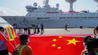 Sri Lankan port workers hold a Chinese national flag to welcome Chinese research ship Yuan Wang 5, bristling with surveillance equipment, as it arrives in Hambantota International Port in Hambantota, Sri Lanka, on 16 August, 2022. AP File