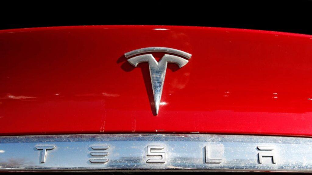 The Tesla logo appears on an unsold 2020 Model X at a dealership. AP