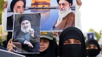 A woman holds a picture of Lebanon's Hezbollah Chief Hassan Nasrallah who was killed by an Israeli airstrike in Beirut. Source: REUTERS.