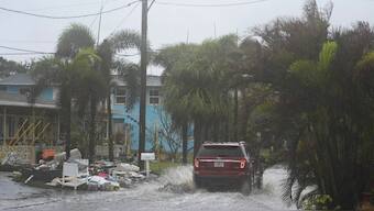 A car drives past a pile of debris from Hurricane Helene flooding, along a street that had already begun flooding from rain ahead of the arrival of Hurricane Milton, in Gulfport, Fla., Wednesday, October 9, 2024. Source: AP. 