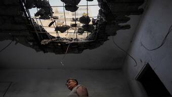 A man examine his damaged apartment that was hit by a rocket fired from Lebanon in Kiryat Yam, northern Israel, on Tuesday. AP 