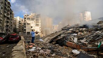 A man documents the damaged buildings at the site of an Israeli airstrike in Beirut's southern suburb, Lebanon, on Tuesday. AP 