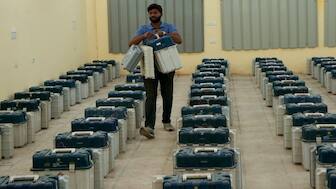 A polling official carries electronic voting machines and other election material for distribution on the eve of the third phase of the Jammu and Kashmir Assembly election, in Jammu, on Monday. AP 