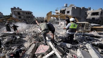 Rescue workers use excavators to remove the rubble of a destroyed building that was hit Tuesday night in an Israeli airstrike, as they search for victims in Sarafand, south Lebanon, on Wednesday. AP 