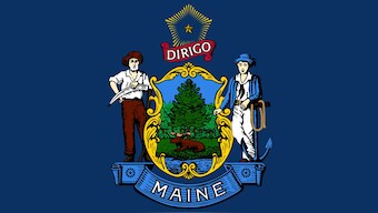 Maine's state flag features a coat of arms that shows a moose-and-pine-tree emblem on a shield supported by a farmer and a sailor. Image courtesy: Wikimedia Commons