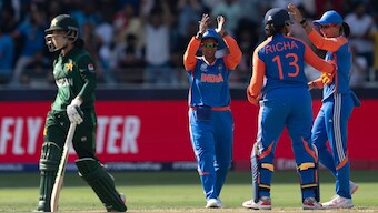 Pakistan captain Fatima Sana walks back to the dugout after getting caught-behind off Asha Shobhana's bowling as the Indian players celebrate behind her. AP