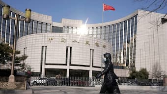 A woman walks past the headquarters of the People's Bank of China, the central bank, in Beijing, China. Source: REUTERS | FILE.