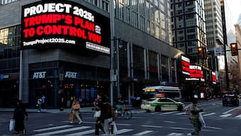 People walk as a digital billboard shows a slogan against Project 2025, ahead of the debate between Republican presidential nominee and former U.S. President Donald Trump and Democratic presidential nominee and US Vice President Kamala Harris, in Philadelphia, Pennsylvania, US, on September 10, 2024. Reuters