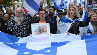 A participant displays a photo of a family held hostage by Palestinian militants in the Gaza Strip, during a rally in front of the Brandenburg Gate in central Berlin on October 6, 2024, ahead of the one-year anniversary of the October 7 attack on Israel by Palestinian militant group Hamas which triggered the war in Gaza.- Photo- AFP