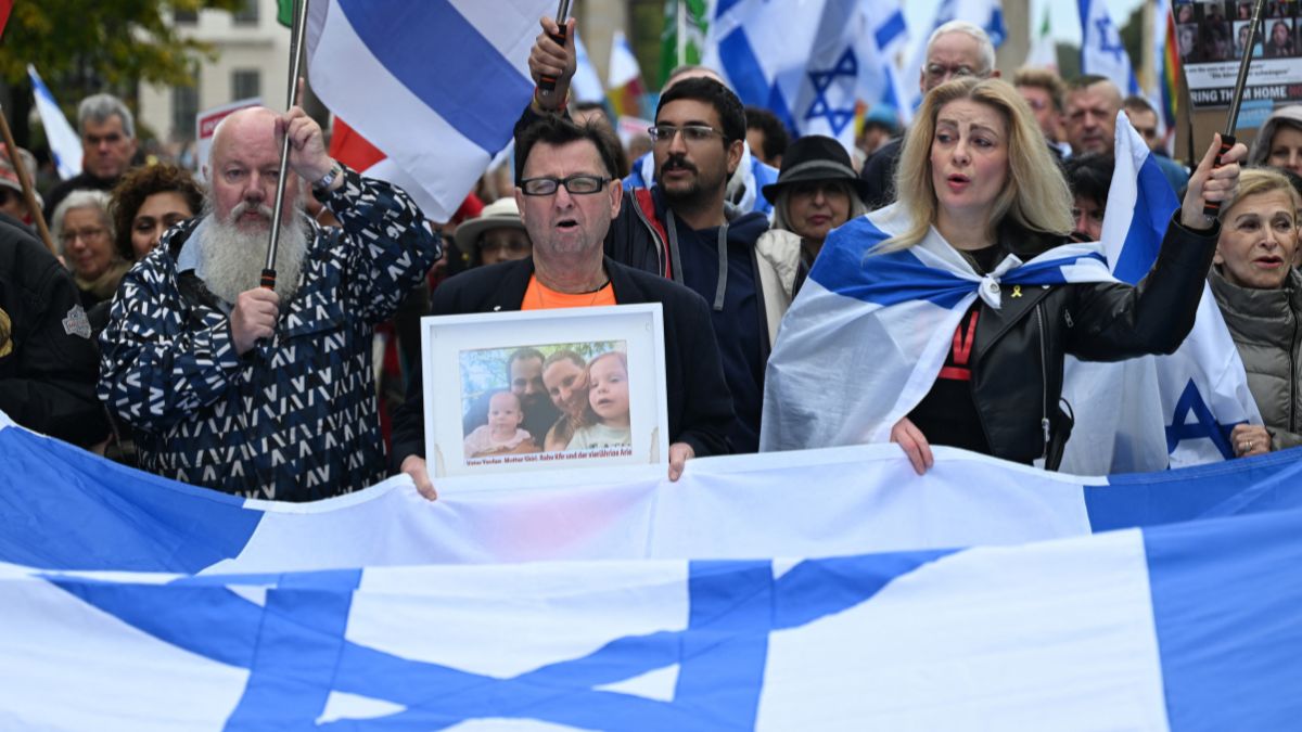 A participant displays a photo of a family held hostage by Palestinian militants in the Gaza Strip, during a rally in front of the Brandenburg Gate in central Berlin on October 6, 2024, ahead of the one-year anniversary of the October 7 attack on Israel by Palestinian militant group Hamas which triggered the war in Gaza.- Photo- AFP A participant displays a photo of a family held hostage by Palestinian militants in the Gaza Strip, during a rally in front of the Brandenburg Gate in central Berlin on October 6, 2024, ahead of the one-year anniversary of the October 7 attack on Israel by Palestinian militant group Hamas which triggered the war in Gaza.- Photo- AFP