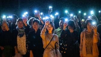 People hold up their lit mobile phones as they take part in a candlelight vigil in front of Zojoji temple in Tokyo on October 5, 2024, to call for a ceasefire in Gaza. Photo- AFP