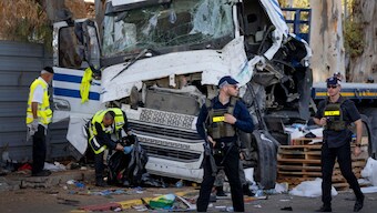 Israeli police and rescue services inspect the site where a truck driver rammed into a bus stop near an army base, wounding dozens of people, according to Israel's Magen David Adom rescue service in Ramat Hasharon, Israel, Sunday, Oct. 27, 2024.  Image- AP