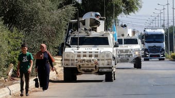 (File) People walk near UN peacekeepers (UNIFIL) vehicles in Marjayoun, near the border with Israel, in southern Lebanon on August 9, 2024. Reuters