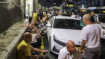 Israelis take cover behind vehicles under a bridge along the side of a highway in Tel Aviv. AFP