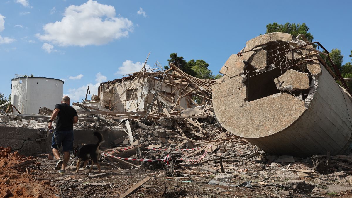 A man walks with a dog past a the rubble of a destroyed building in Hod HaSharon in the aftermath of an Iranian missile attack on Israel, on October 2, 2024. AFP A man walks with a dog past a the rubble of a destroyed building in Hod HaSharon in the aftermath of an Iranian missile attack on Israel, on October 2, 2024. AFP