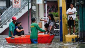 Residents use a boat to cross flooded streets caused by Tropical Storm Trami on Friday, Oct. 25, 2024, in Cainta, Rizal province, Philippines. AP