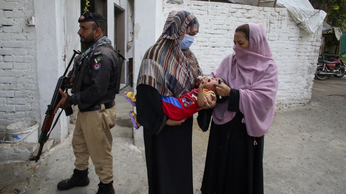 A police officer stands guard as a health worker, right, administers a polio vaccine to a child in Peshawar, Pakistan, September 9, 2024. File Photo/AP
A police officer stands guard as a health worker, right, administers a polio vaccine to a child in Peshawar, Pakistan, September 9, 2024. File Photo/AP